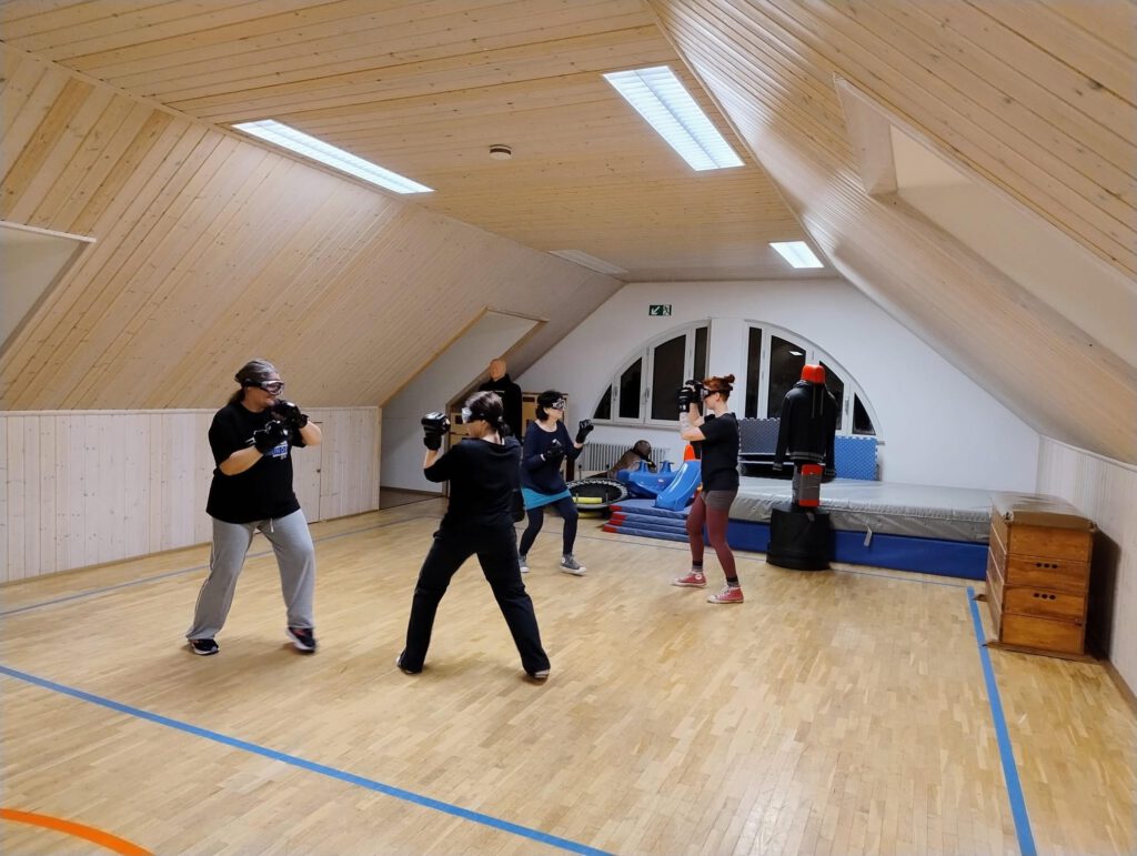 Zwei Trainingspaare üben mit Handschuhen und Schutzbrillen